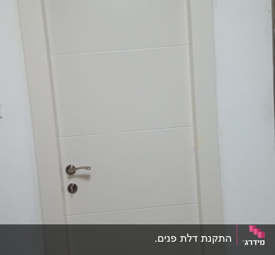 דלת לבנה עם ידית מתכת כסופה